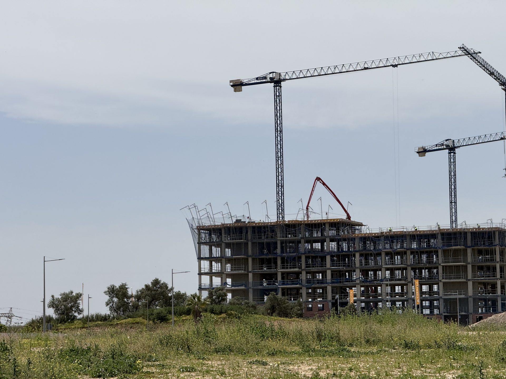 Edificio plurifamiliar en construcción con grúas torre junto a la Parcela BA-16 en Entrenúcleos, Dos Hermanas (Sevilla)